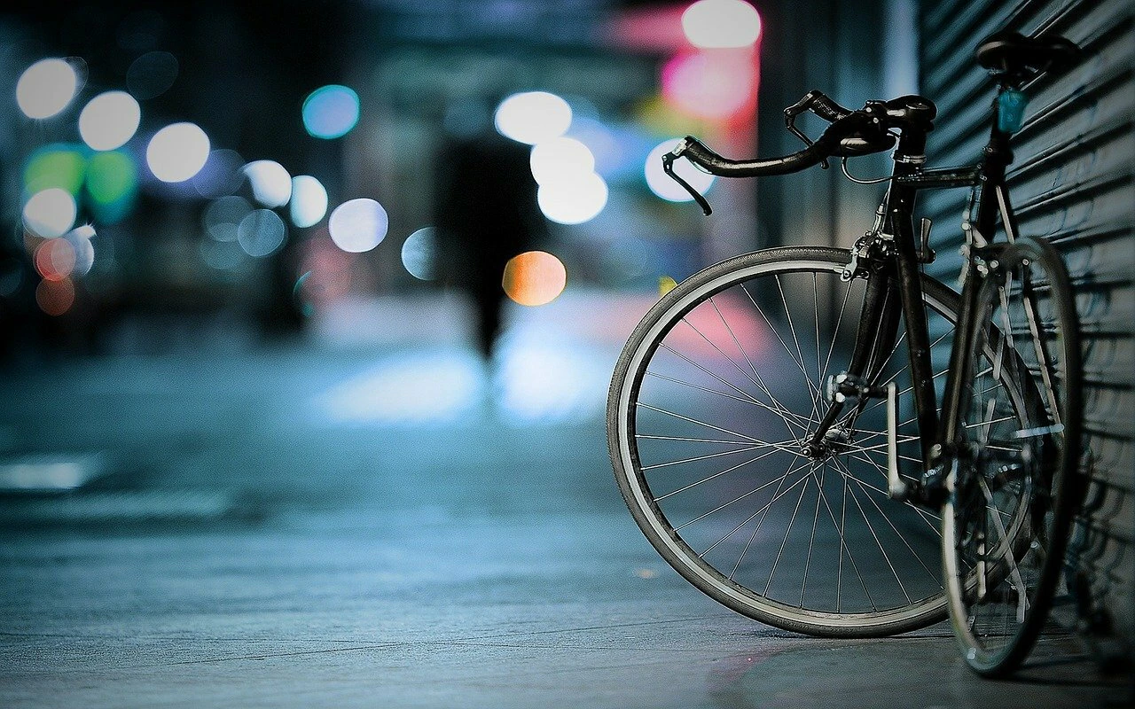 Ein Fahrrad steht nachts abgestellt auf einem Weg
