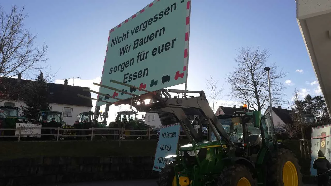 Ein Traktor mit einem Schild auf dem "Nicht vergessen - Wir Bauern sorgen für euer Essen" steht