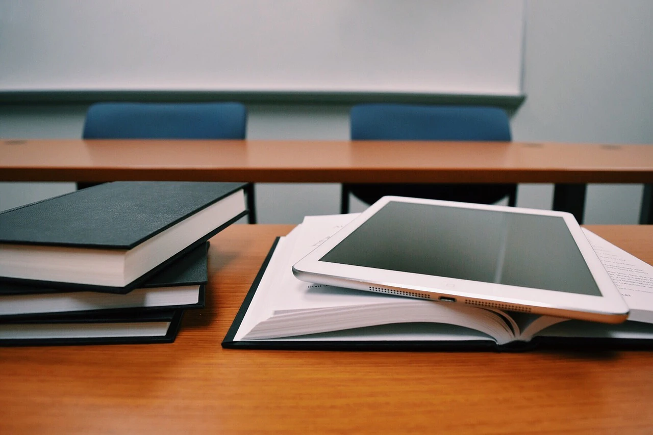Buch und Tablet auf einem Schreibtisch — © Symbolbild