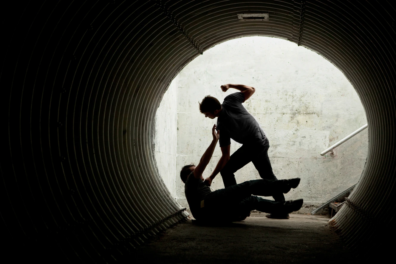 Ein Mann wird in einem Tunnel von einem anderen niedergeschlagen