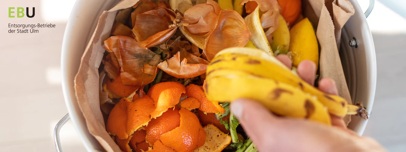 Eine Bananenschale wird in den Biomüll geworfen