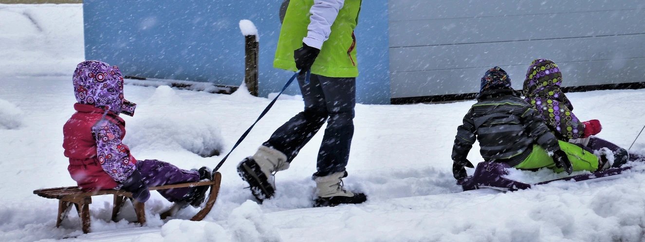 Eine Familie beim Rodeln im Schnee