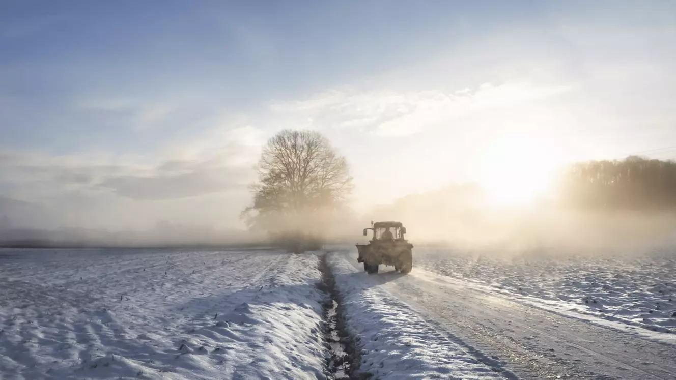 Ein Traktor auf einer verschneiten Straße