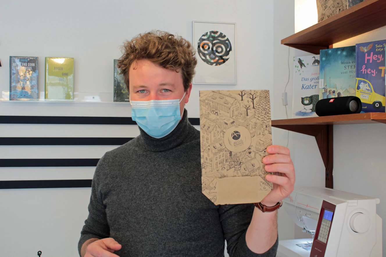 Chef der Buchhandlung zeigt seine neuen umweltfreundlichen Geschenkverpackungen