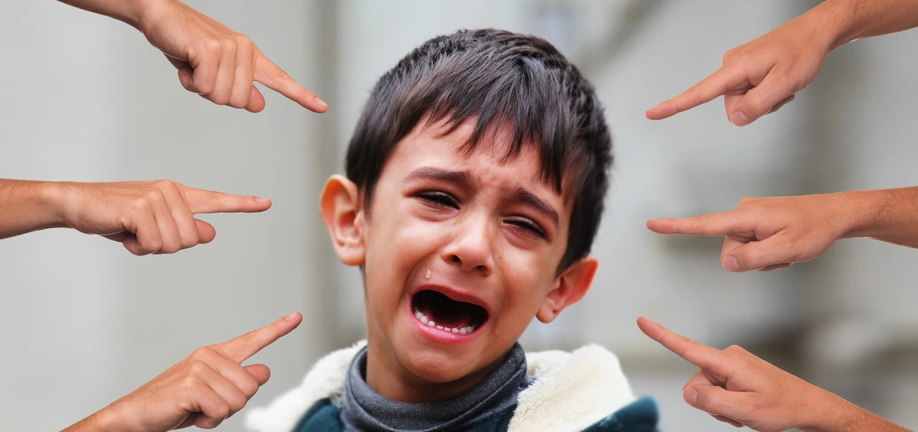 viele Finger zeigen auf einen weinenden Jungen