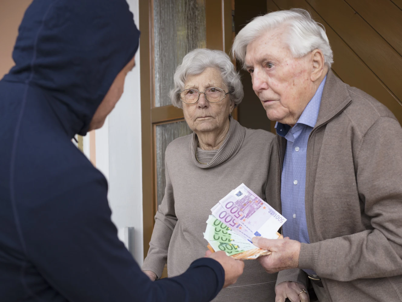 Ein Betrüger, der einem alten Ehepaar Geld wegnehmen will
