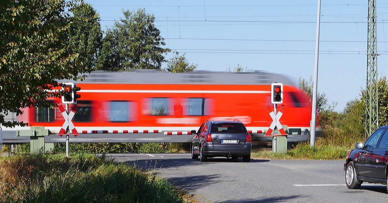 Ein fahrender Zug am Bahnübergang