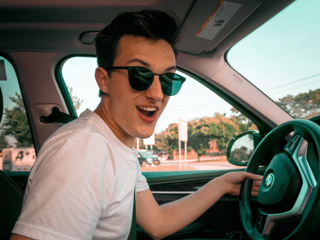 Ein junger Autofahrer mit Sonnenbrille