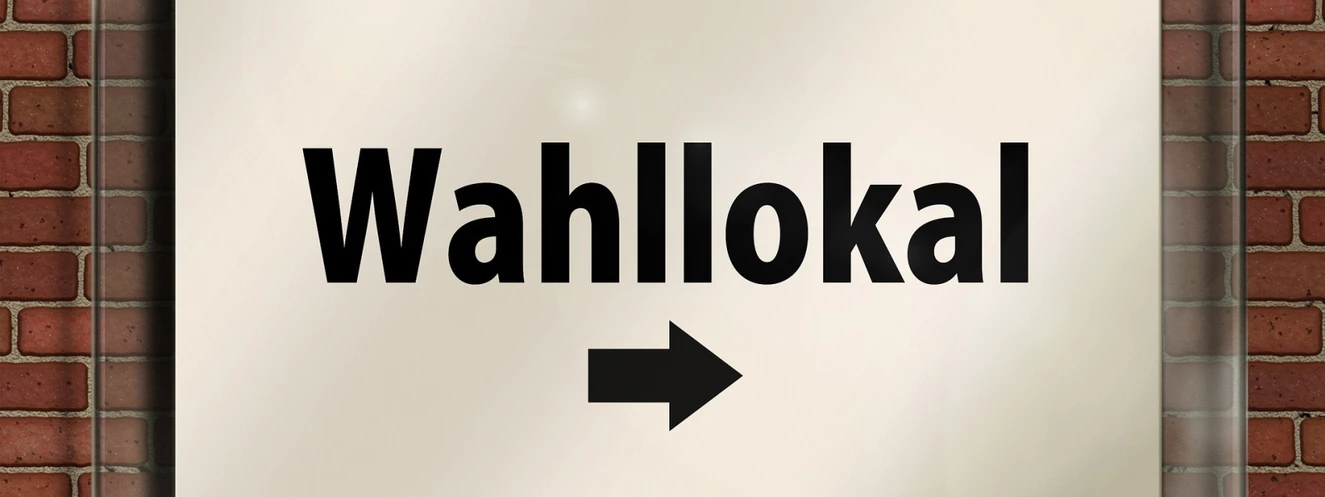 Das Wort Wahllokal auf einem Schild mit einem Pfeil