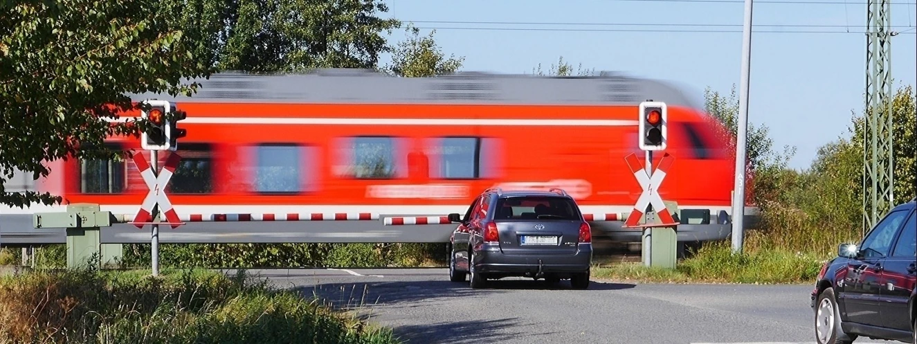 Ein fahrender Zug am Bahnübergang