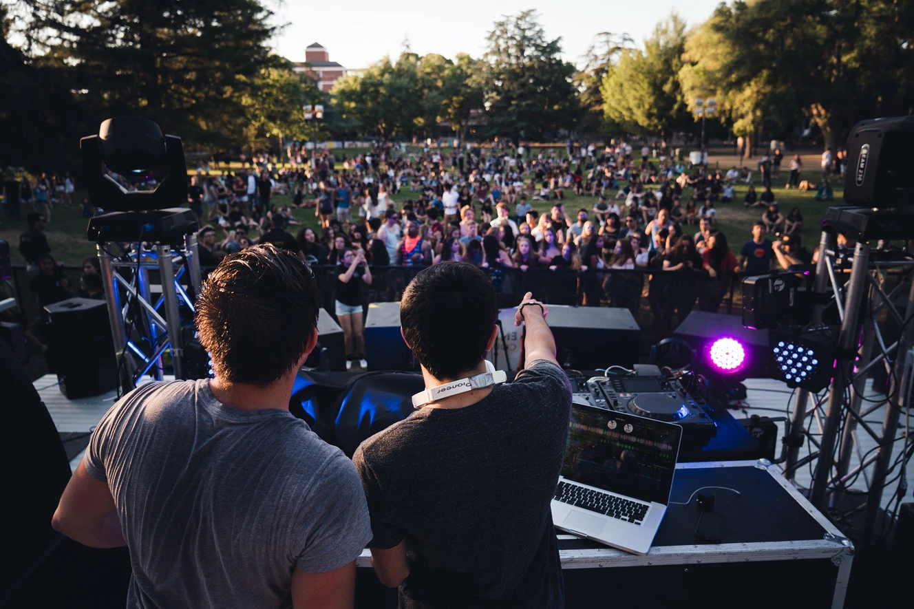 Zwei DJs stehen auf einer Bühne vor Publikum — © Symbolbild