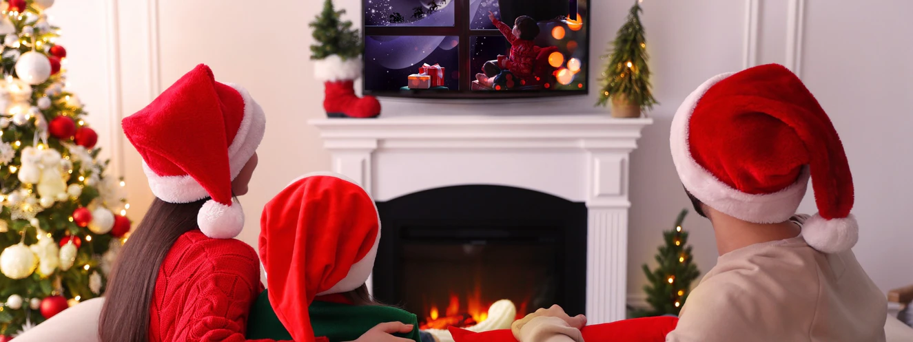 Familie schaut im Wohnzimmer einen Weihnachtsfilm zur Weihnachtszeit
