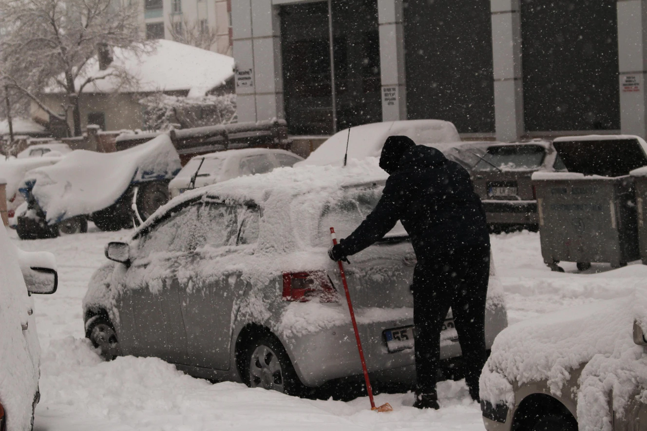 Mann befreit sein Auto von Schnee