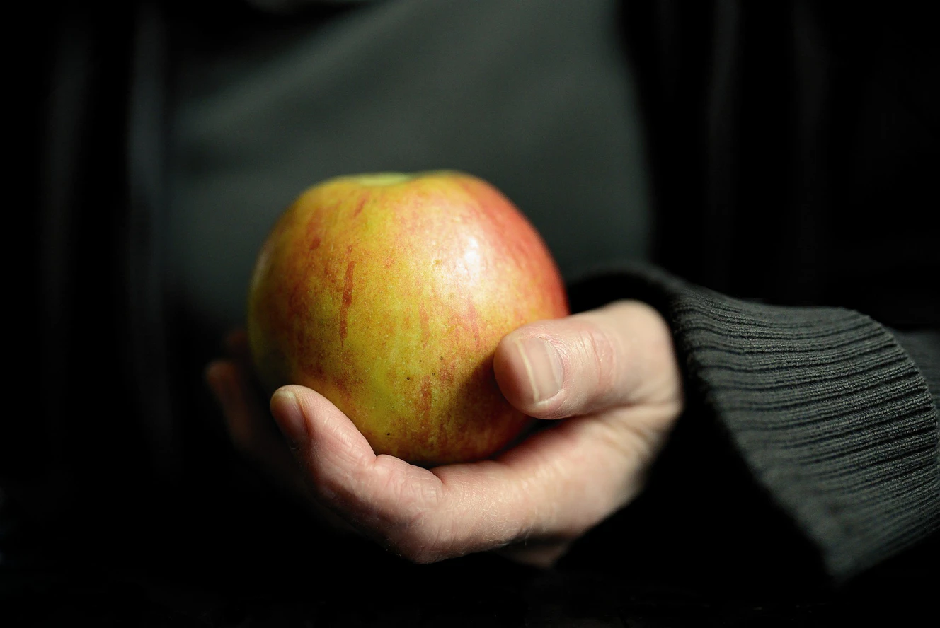 Eine Frau hält einen Apfel in der Hand