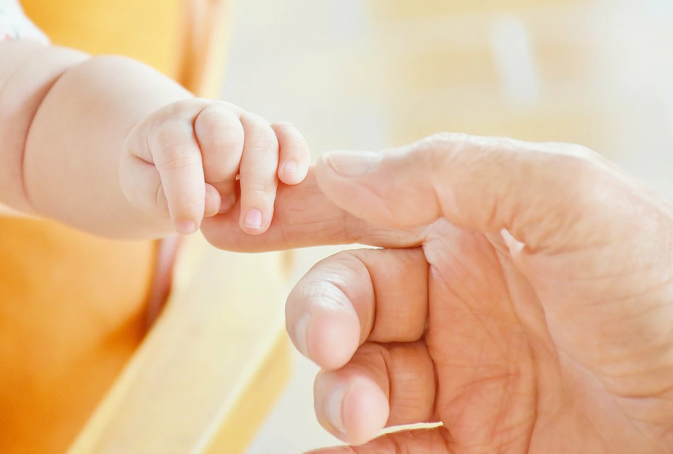 Mutterhand hält Babyhand