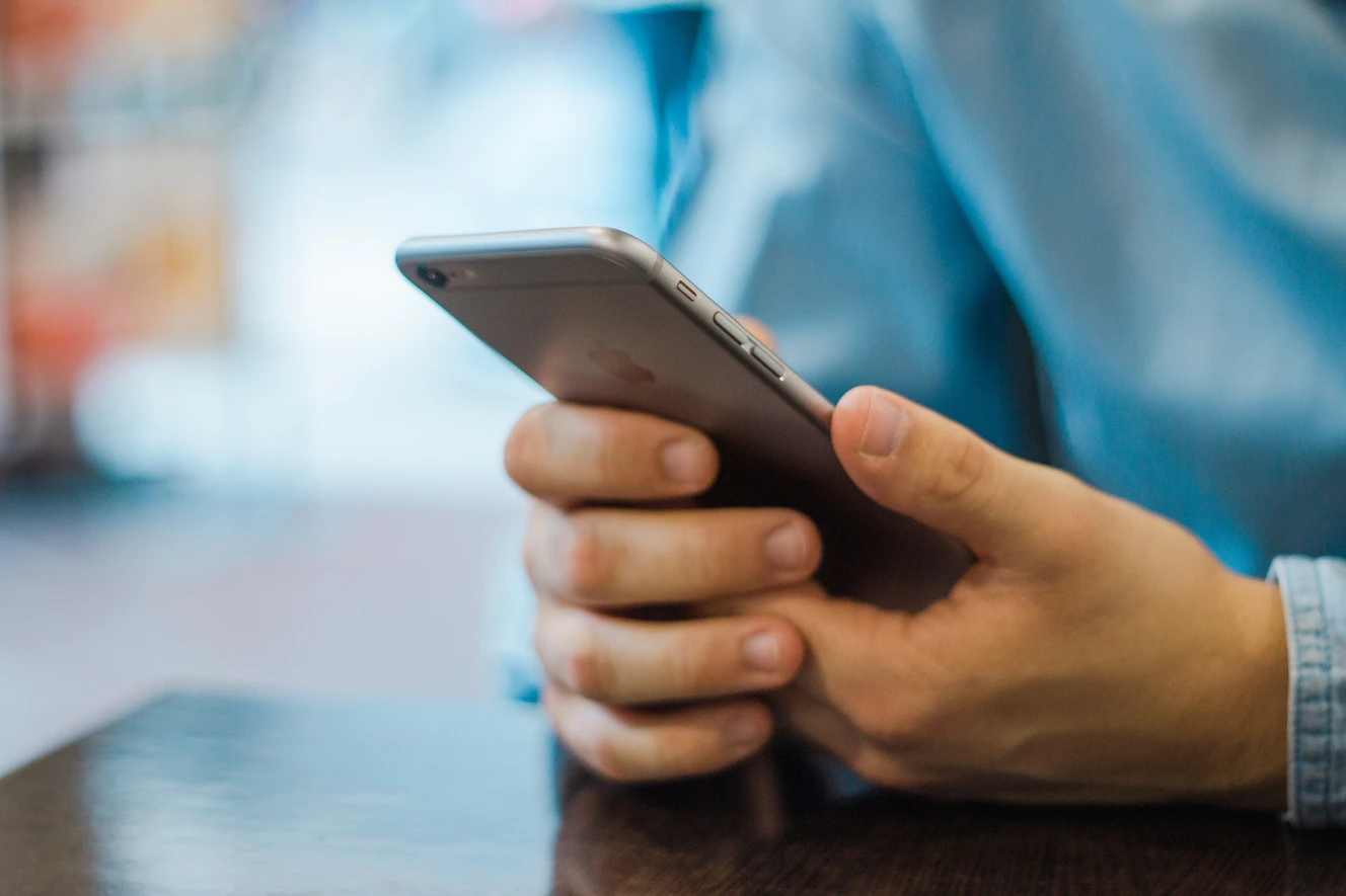 Ein Mann hält ein Handy in der Hans