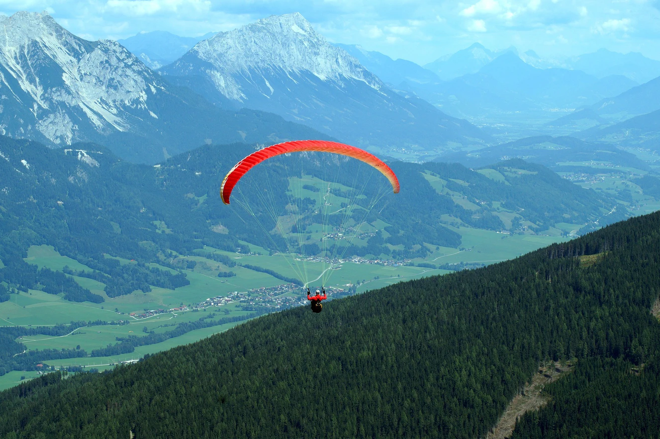 Ein Mann fliegt mit seinem Gleitschirm