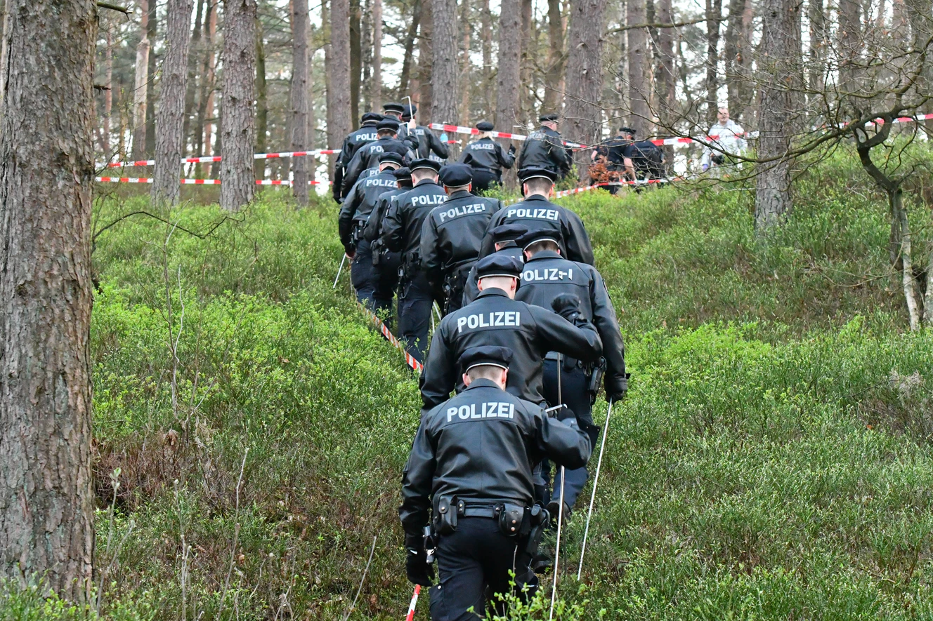 Eine Polizeistaffel sucht im Wald nach einer Person