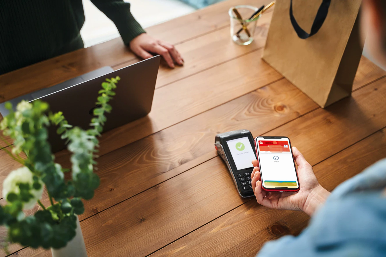 Eine Person zahlt Bargeldlos mit ihrem Handy