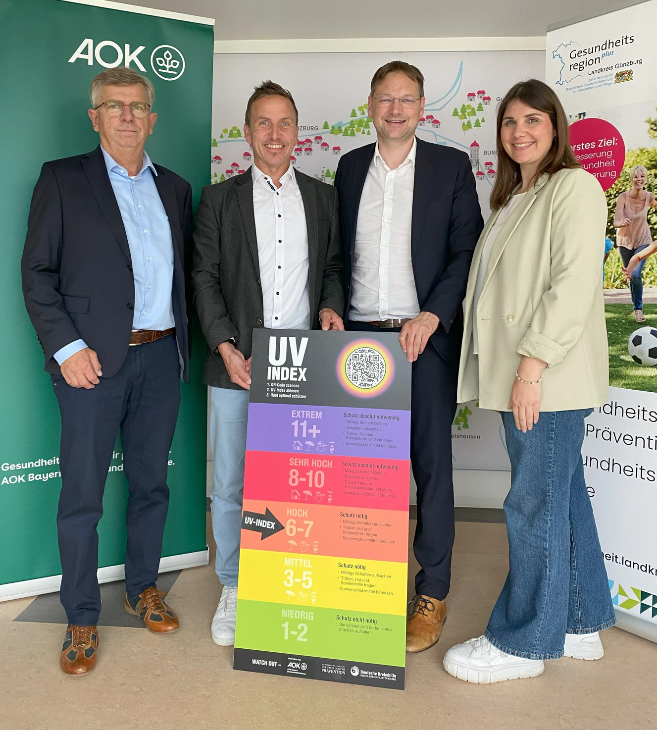Bernd Mayer, Direktor Direktor der AOK Direktion Günzburg (Zweiter von links), Landrat Hans Reichhart und die Geschäftsstellenleiter der GesundheitsregionPlus Günzburg, Hermann Keller (links) und Anna-Maria Margraf (rechts), mit der UV-Index-Tafel. — © Benjamin Sigmund/Landratsamt Günzburg