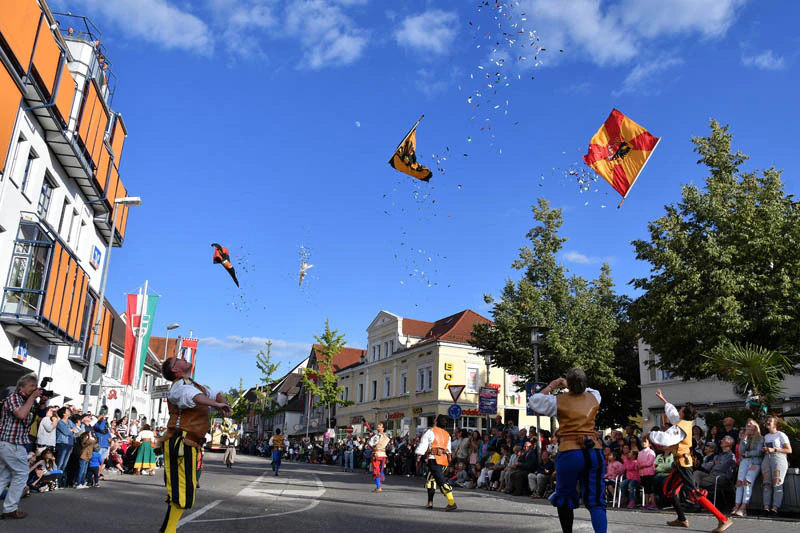 Darsteller werfen Fahnen in einem Festumzug in die Luft — © Otto Marx