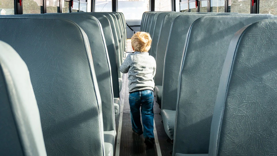 Kind im Mittelgang eines Busses