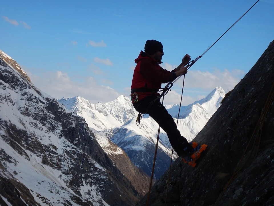 Bergsteiger an einer Felswand mit Seil