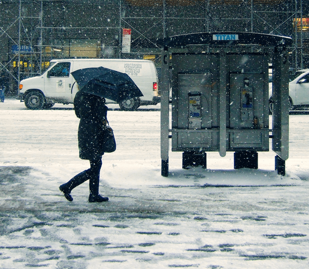 Mensch geht in verschneiter Stadt spazieren