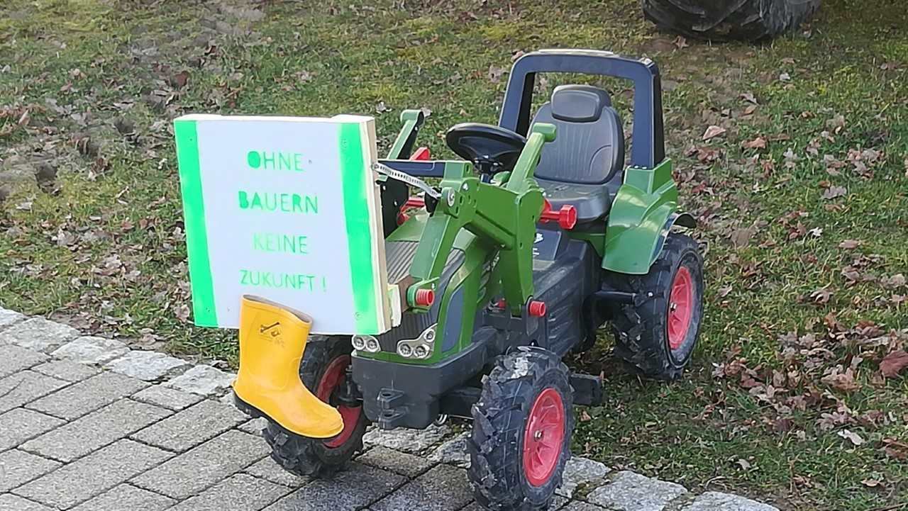 An einem Kindertraktor ist ein Schild mit der Aufschrift 